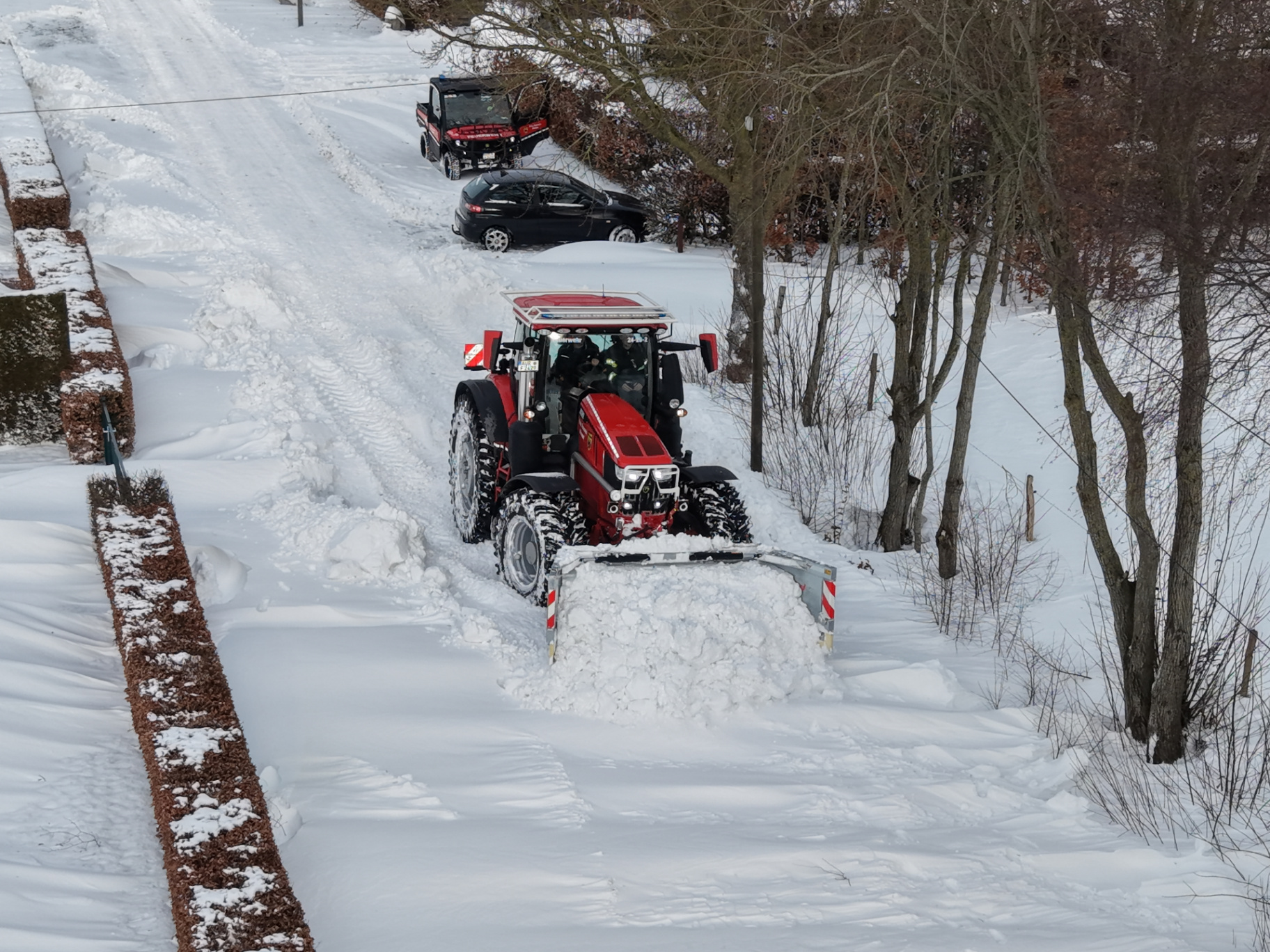 Einsatztraktor mit Räumschild im Winterdiensteinsatz